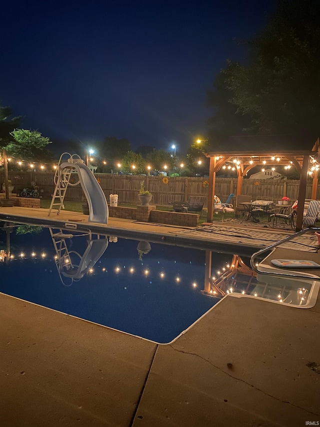 281 Dayton Rd, Dayton, IN 47941 - pool at night featuring a water slide, a gazebo, a patio area, and a fenced backyard