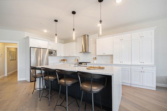 1740301W S Bend Ave, South Bend, IN 46637 - kitchen featuring wall chimney range hood, appliances with stainless steel finishes, baseboards, light wood finished floors, and white cabinetry