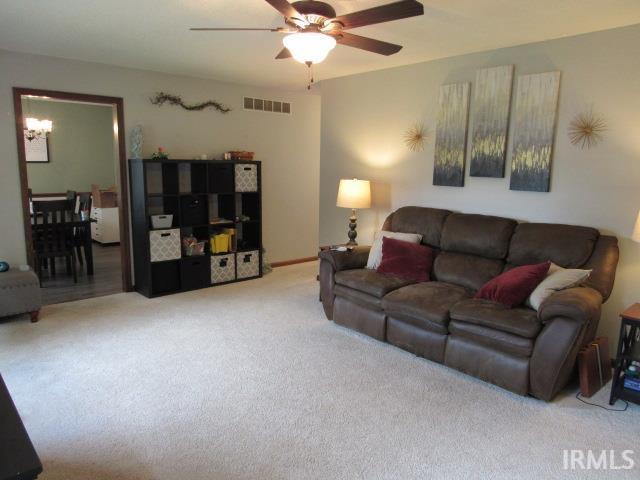 2011 Tanglewood Dr, Mount Vernon, IN 47620 - carpeted living area featuring ceiling fan and a chandelier