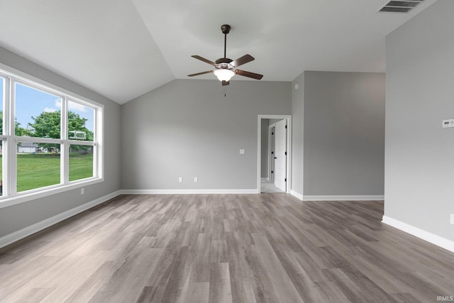 spare room featuring ceiling fan, wood finished floors, lofted ceiling, and baseboards