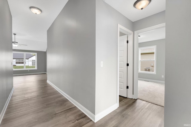 hallway with wood finished floors and baseboards