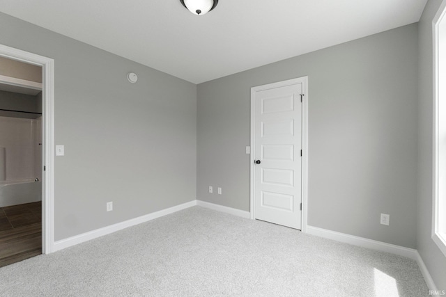 unfurnished bedroom featuring light colored carpet and baseboards