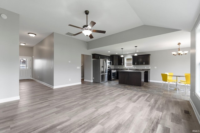 unfurnished living room featuring light wood-type flooring, a ceiling fan, vaulted ceiling, a chandelier, and baseboards