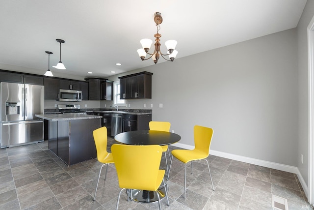 dining room with baseboards, a chandelier, stone finish floors, and recessed lighting