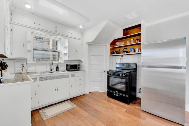 1820 Saint Marys Ave, Fort Wayne, IN 46808 - kitchen with appliances with stainless steel finishes, a sink, backsplash, white cabinets, and light wood-style flooring