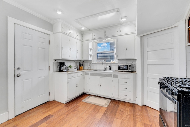 1820 Saint Marys Ave, Fort Wayne, IN 46808 - kitchen featuring a sink, black gas range, decorative backsplash, white cabinetry, and ornamental molding