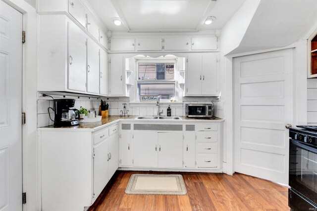 1820 Saint Marys Ave, Fort Wayne, IN 46808 - kitchen with a sink, black range oven, white cabinets, and wood finished floors