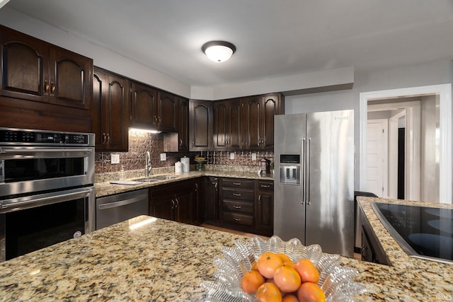602 Cherokee Ave, Lafayette, IN 47905 - kitchen with appliances with stainless steel finishes, a sink, light stone counters, dark brown cabinets, and decorative backsplash