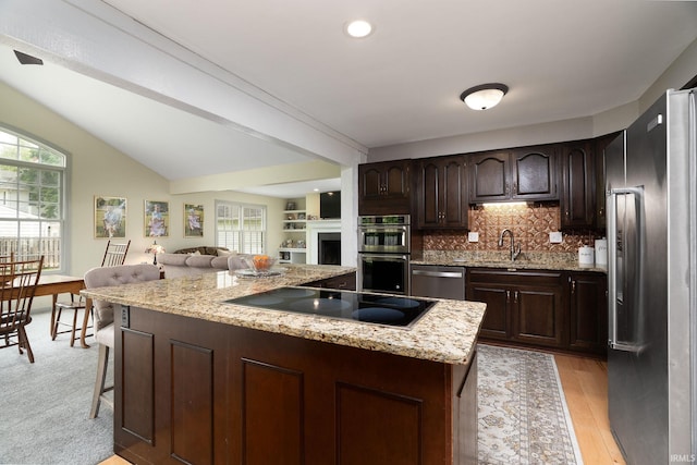 602 Cherokee Ave, Lafayette, IN 47905 - kitchen with appliances with stainless steel finishes, plenty of natural light, a center island, dark brown cabinetry, and lofted ceiling