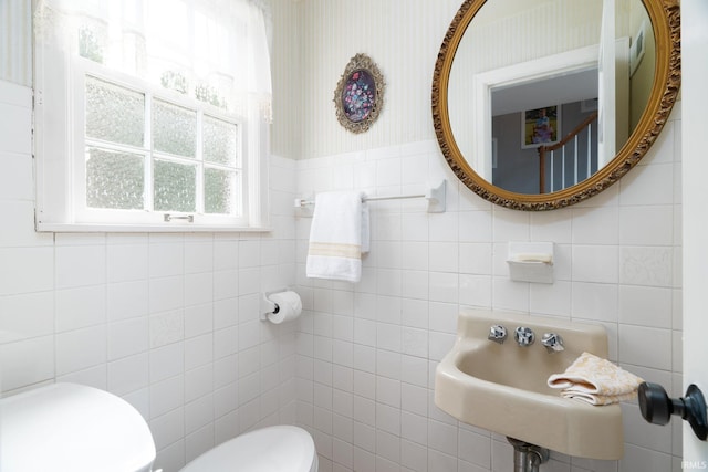 602 Cherokee Ave, Lafayette, IN 47905 - half bath with tile walls, toilet, a sink, wallpapered walls, and a wainscoted wall