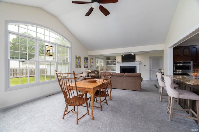 602 Cherokee Ave, Lafayette, IN 47905 - dining room with light carpet, ceiling fan, a fireplace, baseboards, and high vaulted ceiling