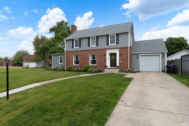 602 Cherokee Ave, Lafayette, IN 47905 - colonial home with an attached garage, a chimney, driveway, and brick siding