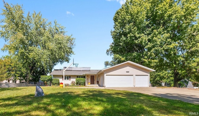 ranch-style house with an attached garage, roof mounted solar panels, and concrete driveway