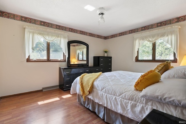 bedroom with wood finished floors and baseboards
