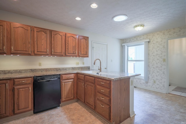 kitchen featuring dishwasher, a sink, a peninsula, brown cabinetry, and a textured ceiling