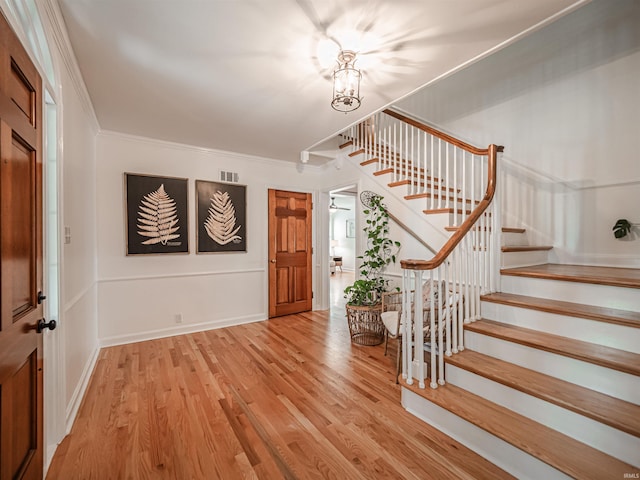 727 Mulberry St, Mount Vernon, IN 47620 - entrance foyer with stairs, ornamental molding, wood finished floors, and a chandelier