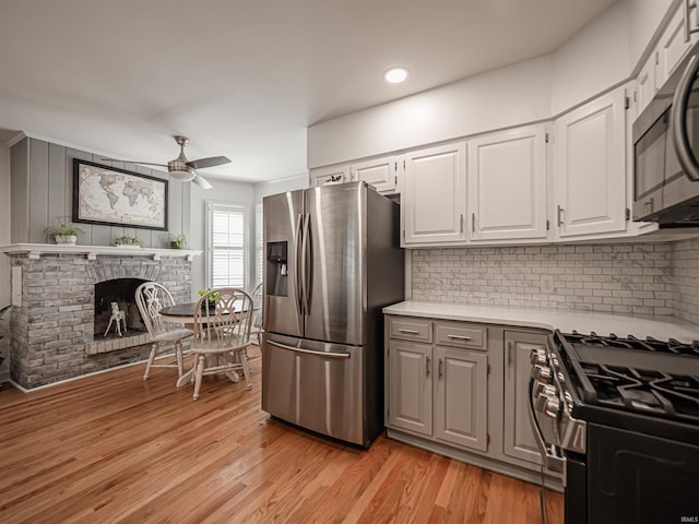 727 Mulberry St, Mount Vernon, IN 47620 - kitchen with appliances with stainless steel finishes, ceiling fan, light countertops, backsplash, and light wood-style floors
