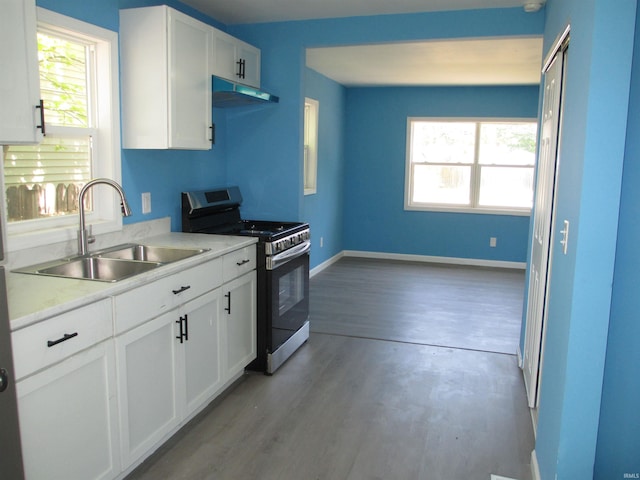 509 S Chicago St, South Bend, IN 46619 - kitchen with stainless steel gas range oven, a sink, under cabinet range hood, light countertops, and white cabinets