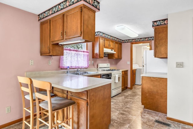 1723 Central St, Lafayette, IN 47905 - kitchen with white appliances, a peninsula, under cabinet range hood, and light countertops