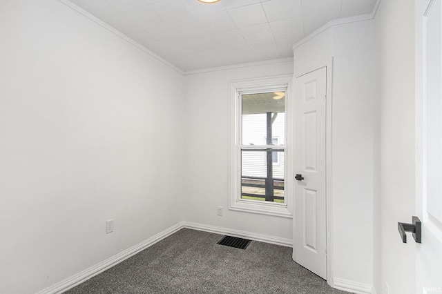 spare room featuring dark carpet, ornamental molding, and baseboards