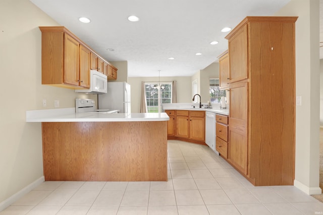 5849 Porterfield Dr, Evansville, IN 47711 - kitchen featuring a peninsula, white appliances, light countertops, recessed lighting, and a sink
