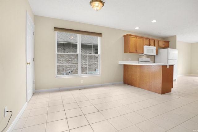 5849 Porterfield Dr, Evansville, IN 47711 - kitchen featuring white appliances, a peninsula, light countertops, brown cabinetry, and baseboards