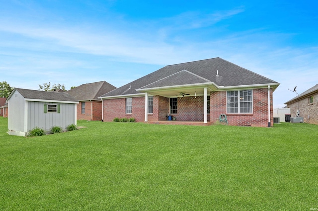 5849 Porterfield Dr, Evansville, IN 47711 - back of property featuring ceiling fan, a yard, brick siding, an outbuilding, and roof with shingles