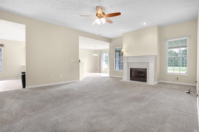 5849 Porterfield Dr, Evansville, IN 47711 - unfurnished living room featuring healthy amount of natural light, light carpet, ceiling fan, and a tile fireplace