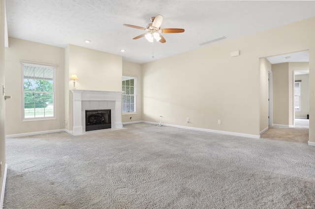 5849 Porterfield Dr, Evansville, IN 47711 - unfurnished living room with carpet flooring, a ceiling fan, a tiled fireplace, baseboards, and recessed lighting