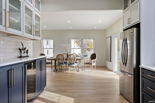 732 S Bend Ave, South Bend, IN 46617 - kitchen with freestanding refrigerator, beverage cooler, light countertops, tasteful backsplash, and light wood-type flooring