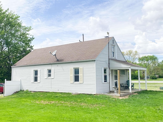 6913 E Jackson St, Muncie, IN 47303 - rear view of house with a lawn, a shingled roof, and covered porch