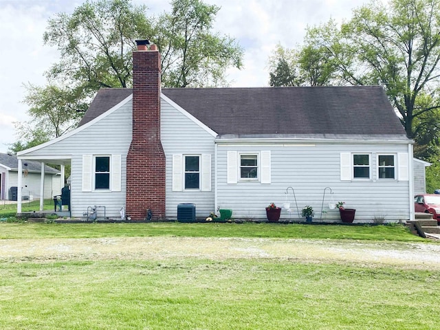 6913 E Jackson St, Muncie, IN 47303 - view of front of property with central AC, a chimney, a front yard, and roof with shingles