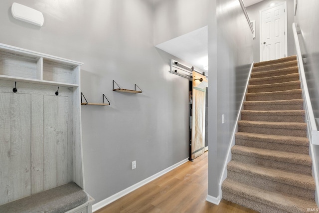 1507 Tara Bella Ln, Fort Wayne, IN 46845 - stairs featuring a barn door, wood finished floors, and baseboards
