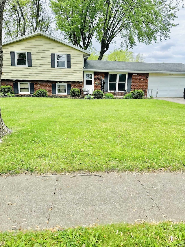 2912 W Twickingham Dr, Muncie, IN 47304 - split level home with a garage, a front yard, driveway, and brick siding