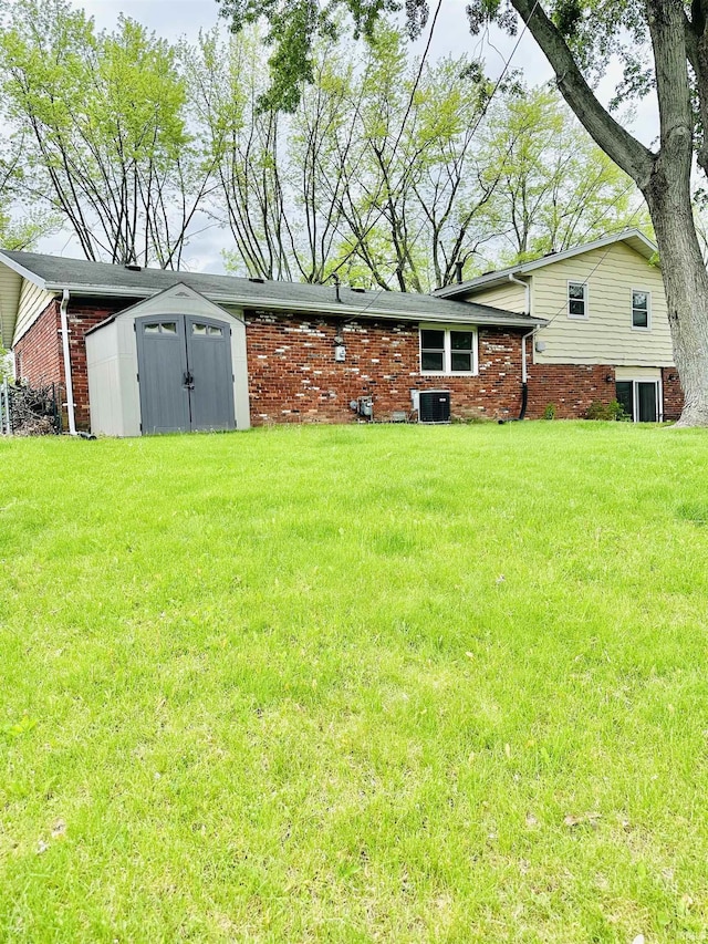 2912 W Twickingham Dr, Muncie, IN 47304 - back of property featuring a storage shed, cooling unit, a lawn, and an outdoor structure