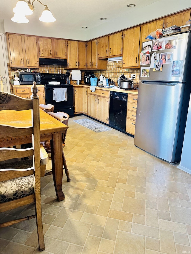 2912 W Twickingham Dr, Muncie, IN 47304 - kitchen with black appliances, under cabinet range hood, decorative backsplash, brown cabinetry, and light countertops