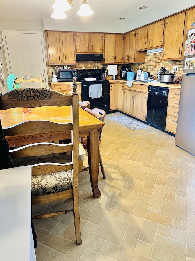 2912 W Twickingham Dr, Muncie, IN 47304 - kitchen featuring black appliances, under cabinet range hood, tasteful backsplash, light countertops, and brown cabinetry