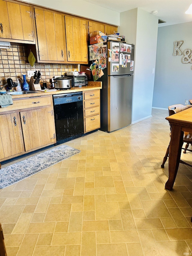 2912 W Twickingham Dr, Muncie, IN 47304 - kitchen with dishwasher, freestanding refrigerator, light countertops, decorative backsplash, and baseboards