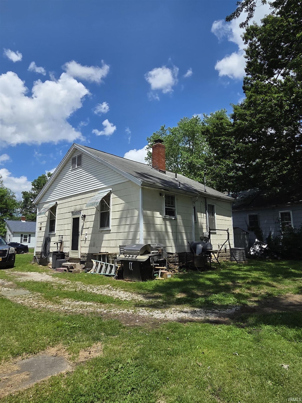view of home's exterior with a chimney and a yard