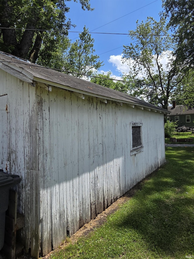 view of side of property featuring a yard and an outdoor structure