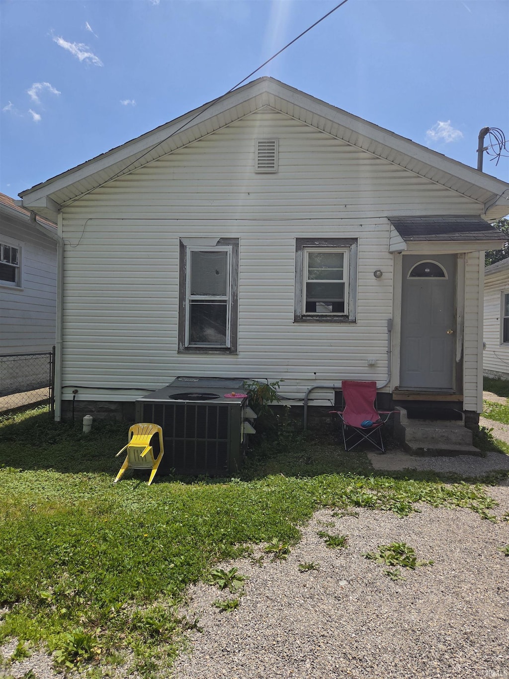back of property with entry steps, cooling unit, and fence