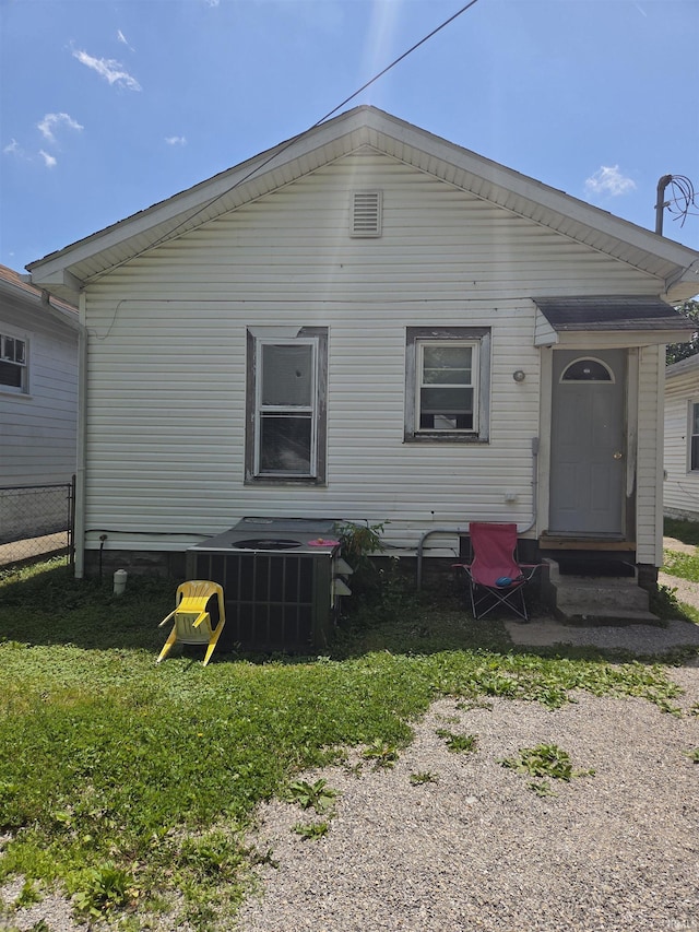 back of property with entry steps, cooling unit, and fence