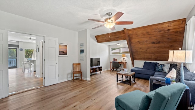 11381 NE Wawasee Dr, Syracuse, IN 46567 - living room with light wood-style flooring, ceiling fan, a textured ceiling, and baseboards