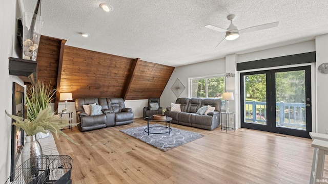 11381 NE Wawasee Dr, Syracuse, IN 46567 - living area featuring wood finished floors, a textured ceiling, vaulted ceiling, and ceiling fan