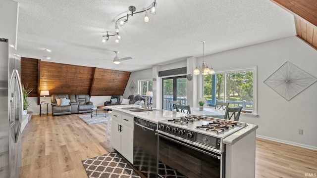 11381 NE Wawasee Dr, Syracuse, IN 46567 - kitchen featuring black dishwasher, range with gas stovetop, freestanding refrigerator, a textured ceiling, and light wood finished floors