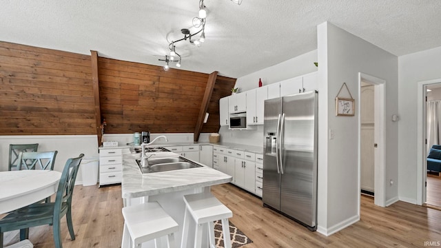11381 NE Wawasee Dr, Syracuse, IN 46567 - kitchen featuring stainless steel appliances, light countertops, white cabinetry, light wood-style flooring, and a textured ceiling