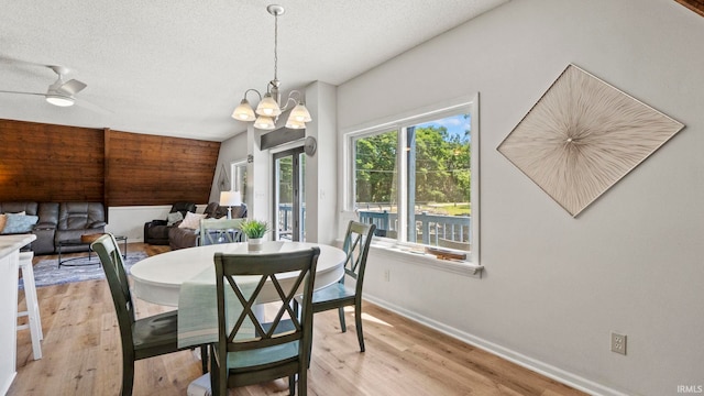 11381 NE Wawasee Dr, Syracuse, IN 46567 - dining room featuring light wood-style floors, baseboards, a chandelier, and a textured ceiling