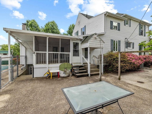 422 E Washingtion St, Oakland City, IN 47660 - rear view of house with a sunroom, a gate, a chimney, and fence