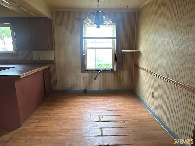 128 S Main St, Griffin, IN 47616 - unfurnished dining area featuring light wood-type flooring, a chandelier, healthy amount of natural light, and wallpapered walls
