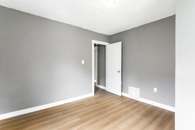 empty room featuring baseboards and light wood-style floors